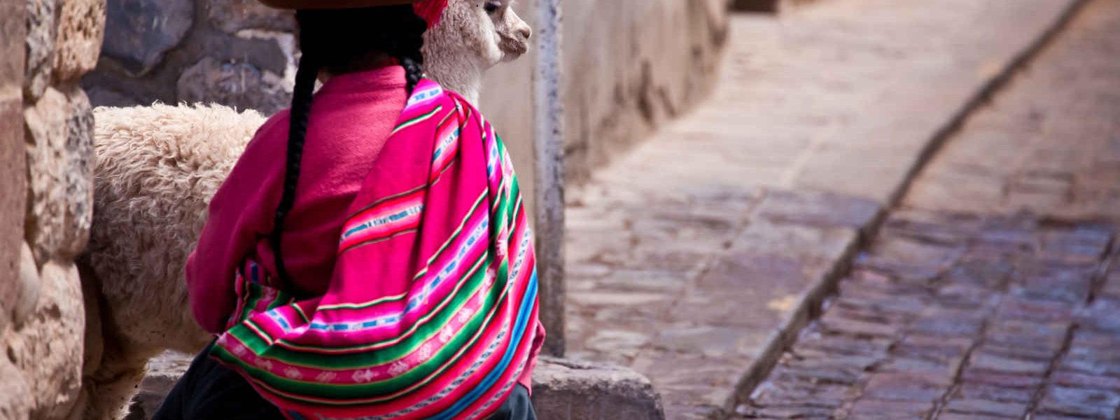 Femme et lama dans une ruelle de Cuzco, Pérou